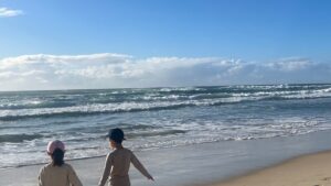 海辺の砂浜を歩く2人の子ども